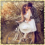 Парень обнимает девушку, сидящую на велосипеде, под цвету...