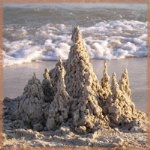 Замок из белого песка у кромки воды