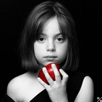 Маленькая девочка с красным яблоком в руках