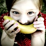 Девочка приложила ко рту банан
