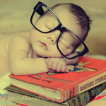 Ребёнок в очках заснул над книгами