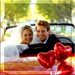 Красивые жених и невеста в свадебном автомобиле с шарами ...