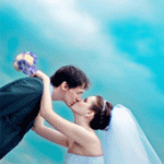 Невеста целует жениха на фоне неба