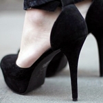 Женские ноги в черных туфлях на шпильках