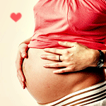 Беременная женщина держится за свой животик