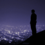 Мужчина с возвышения смотрит на ночной город