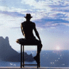 Мужчина в шляпе смотрит на закат