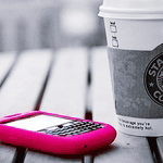  <b>Розовый</b> сотовый телефон и стакан кофе 