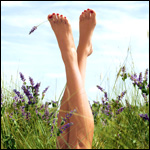 Женские ножки на фоне травы и неба