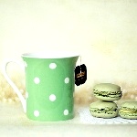 Зеленая кружка с чаем и печенье макаронс (les macarons)