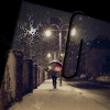 Человек с зонтом на вечерней зимней улице