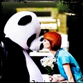 Девушка целует человека в костюме панды