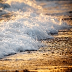 Прибой, пенные волны с шорохом набегают на берег