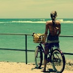 Девушка на велосипеде любуется морем