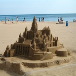 Песчаный замок, на заднем фоне море и люди