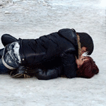 Парень с девушкой целуются лежа на снегу