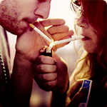 Парень с девушкой прикуривают сигареты
