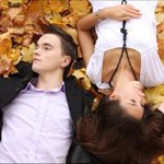 Парень с девушкой лежат на желтых листьях