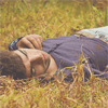  Парень закрыл <b>глаза</b> и лежит на траве 