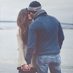 Парень с  девушкой целуются на берегу моря