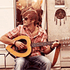 Парень в очках, играющий на гитаре в форме сердца
