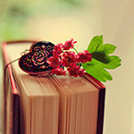 Кулон в виде сердечка и цветы лежат на книге