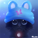 Чёрный котёнок в голубой шапочке с ушками и сидячей на не...