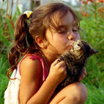Девочка целует котенка