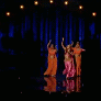 Шакира в окружении двух девушек танцует