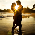  <b>Влюблённые</b> обнимаются на берегу моря в лучах солнца на за... 