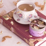 Чайная пара и баночка с лепестками, стоящие на книге, све...