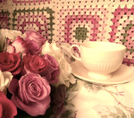 Букет роз и чашка на фоне вязаного коврика