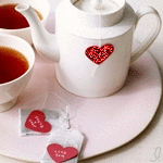  <b>Чайник</b> рядом с чашками наполненными чаем, с пакетиками ча... 