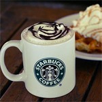Чашка кофе с пенкой от starbucks coffee рядом  с завтраком