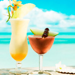 Два коктейля стоят на барной стойке на фоне моря