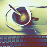 Чашка кофе рядом с клавиатурой, вид сверху