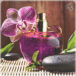Флакон ярко-розовых духов с орхидей и камнем на столе
