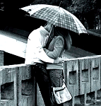 Пара влюбленных целуется под зонтом