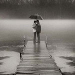 Влюблённые целуются под зонтом на мостках