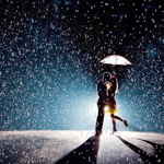 Влюбленная пара под зонтом во время снегопада