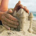  <b>Руки</b> закрывают маленький песочный замок 