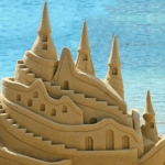 Песчаный замок на фоне голубого моря
