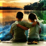 Мальчик с девочкой сидят обнявшись на  деревянном мостике...