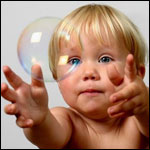  Милый малыш пытается <b>поймать</b> мыльный пузырь 