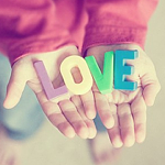Ребенок держит в руках надпись 'love' из букв