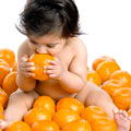 Ребенок кушает апельсины