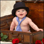 Улыбающийся малыш с черной шляпой на голове и галстуком н...