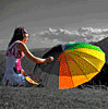 Девочка с разноцветным зонтиком на пляже