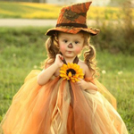 Девочка в шляпе и пышном платье держит подсолнух в руках