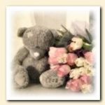 Мишка teddy сидит у букета цветов